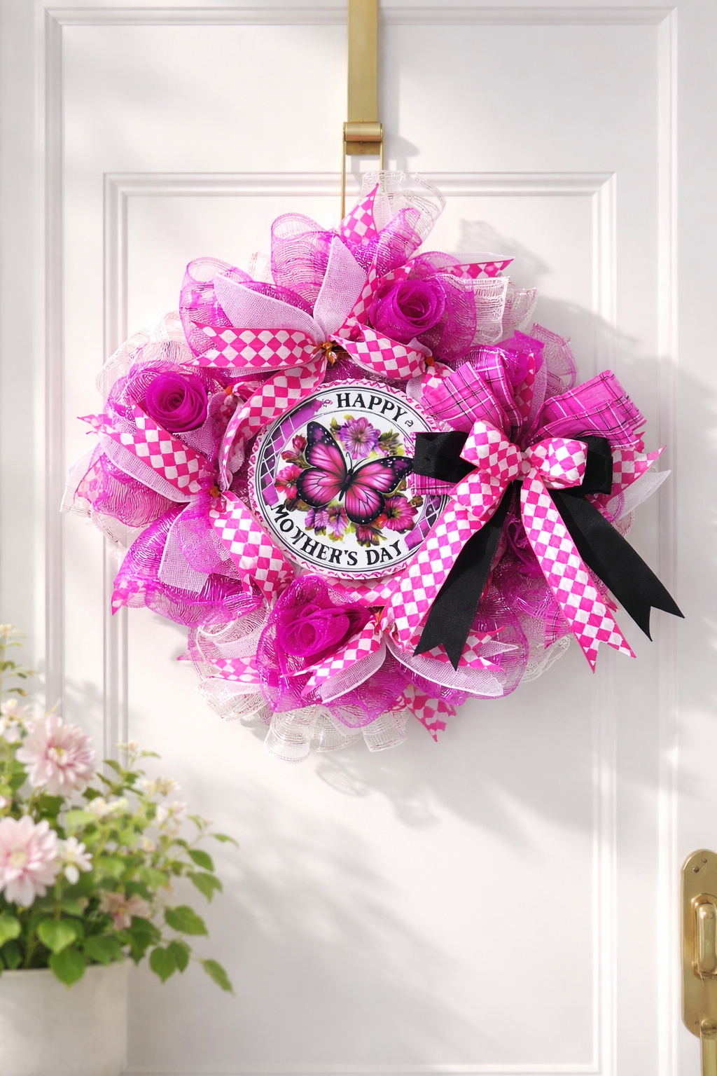 Decorative wreath with pink and purple flowers and a butterfly design on a white door.